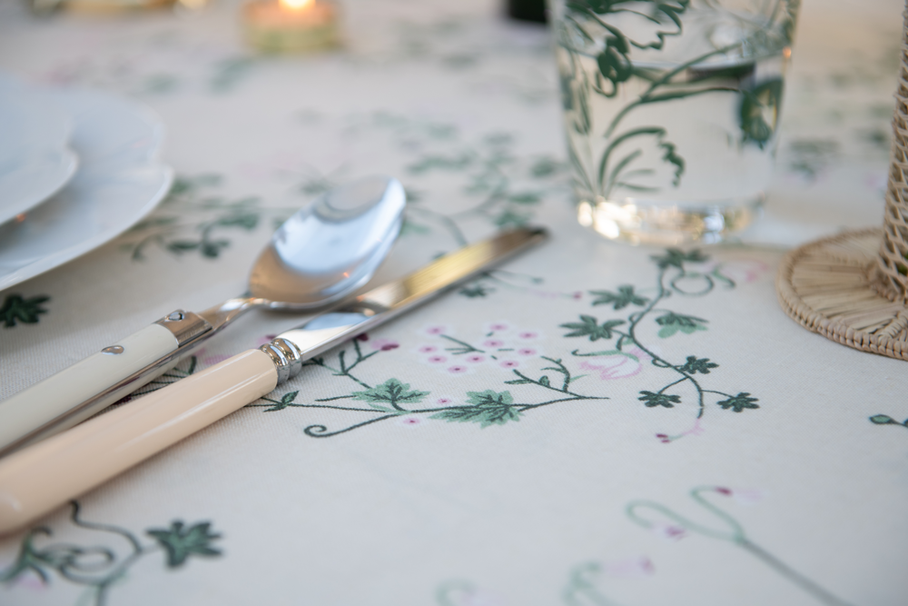 Table setting on green and cream botanica linen tablecloth