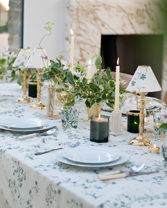 Botanica table setting with linen tablecloth, scented candles, brass tealight stands with botanica candle shades and tealight candle carousels