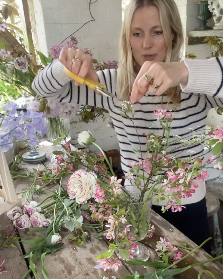 Willow Crossley snipping tips of flowers while creating a vase arrangement